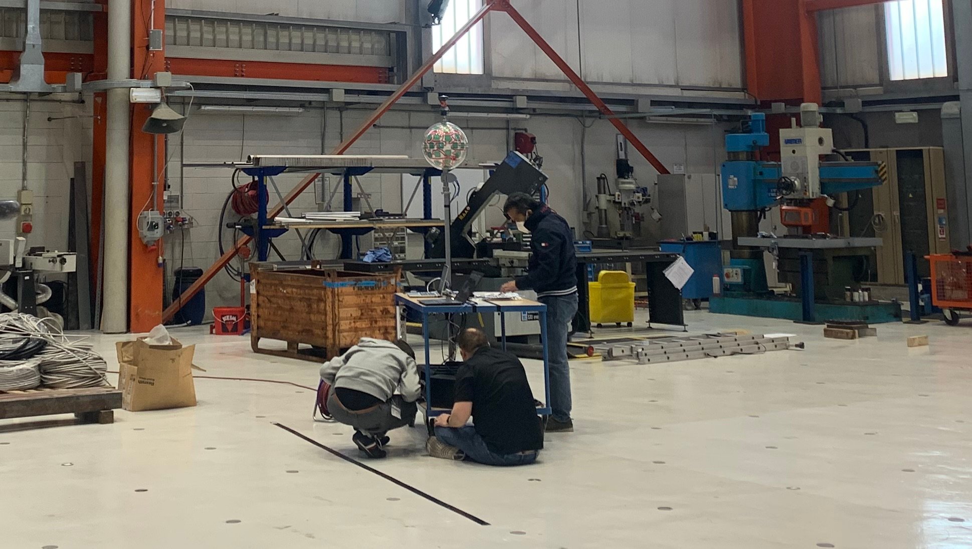 Locata engineers set up the distinctive VRay Orb antenna for an indoor cm-level positioning demo in the Joint Research Centre’s all-metal Workshop Building. (Image: Locata)