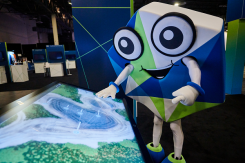 The Hexagon mascot peruses a map during HxGN LIVE 2022. (Photo: Hexagon)